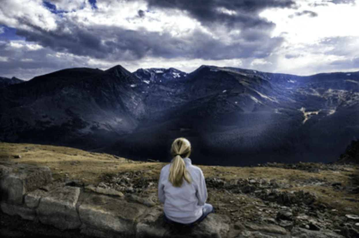 woman sitting on mountain