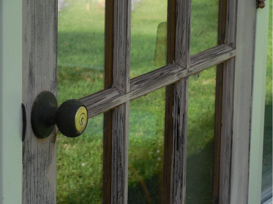 Window with wooden awnings and green grass can be seen.