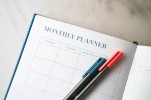 A monthly planner dairy with pens.