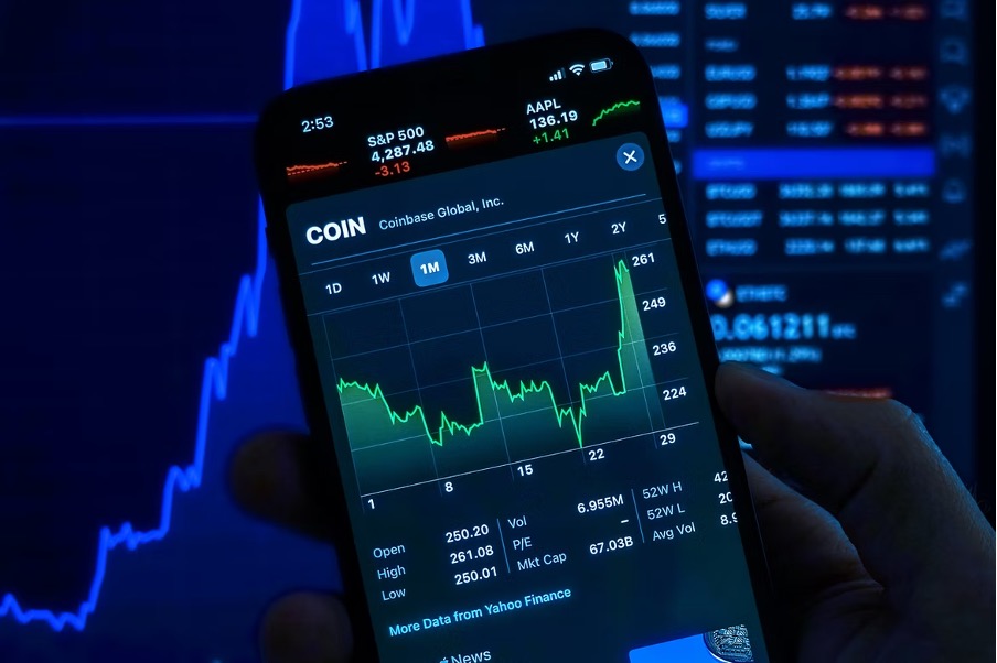 A man holding a phone displaying the cryptocurrencies.