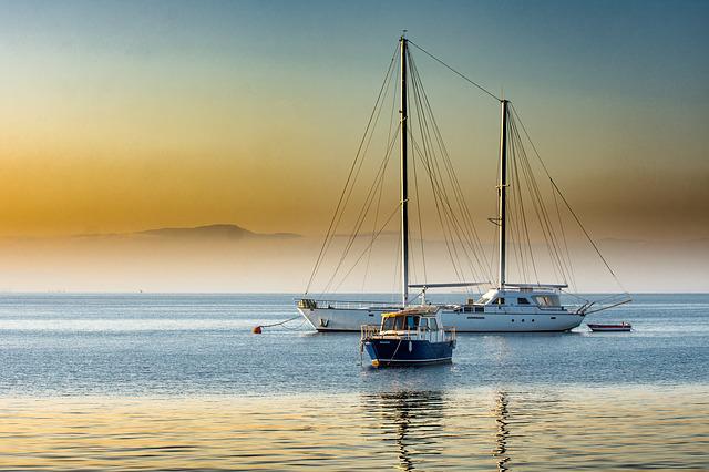 Three boats parked in the sea.