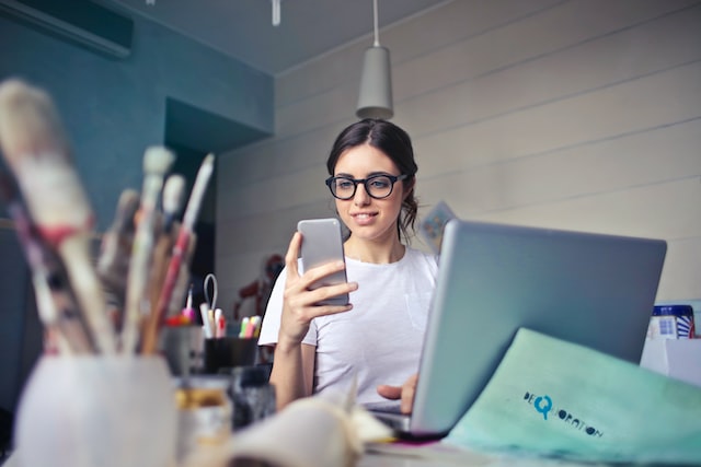 A woman looking into her phone from the office.