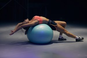 A woman relaxing on a swiss ball.