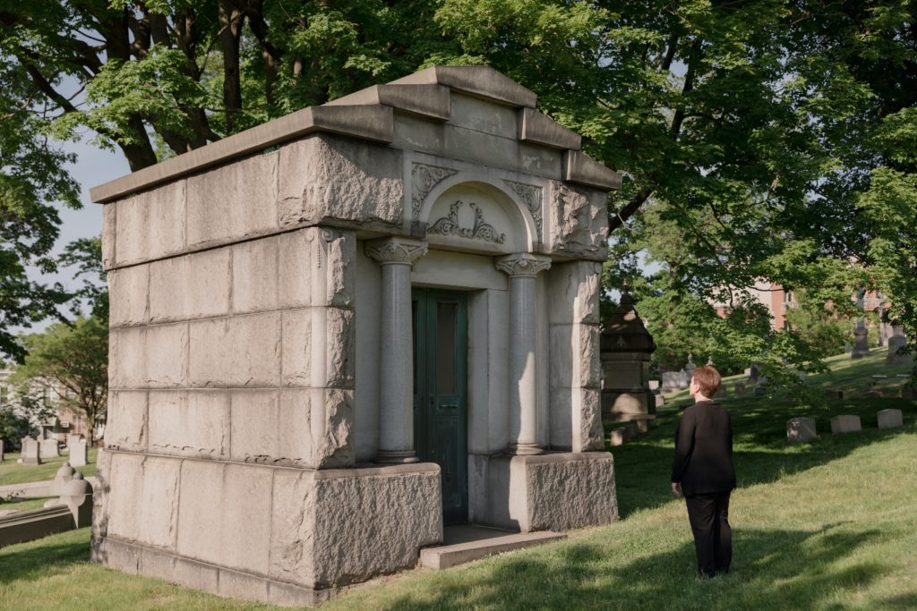 A woman standing in front of a mausoleum.