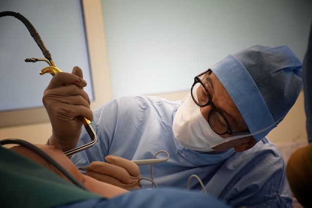 A plastic surgeon performing cosmetic surgery on his patient.