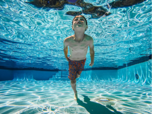 A boy swimming under the water.