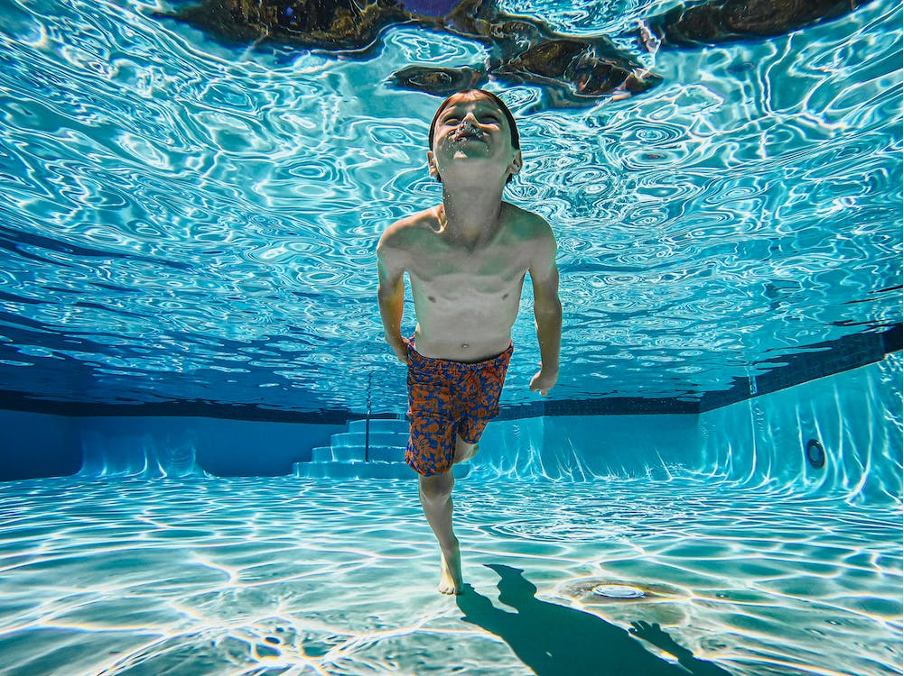 A boy swimming under the water.