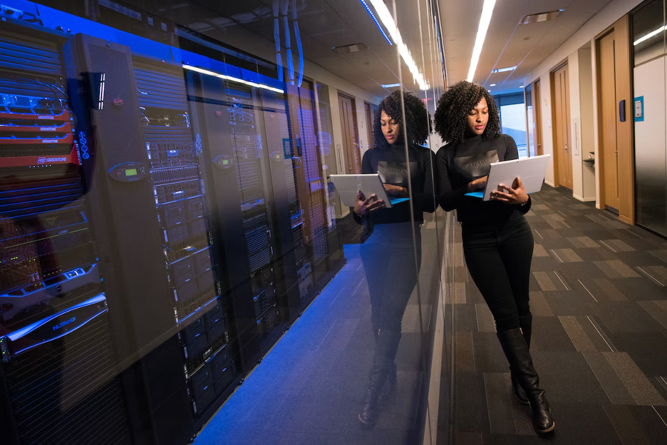 A woman standing and looking in to the laptop.