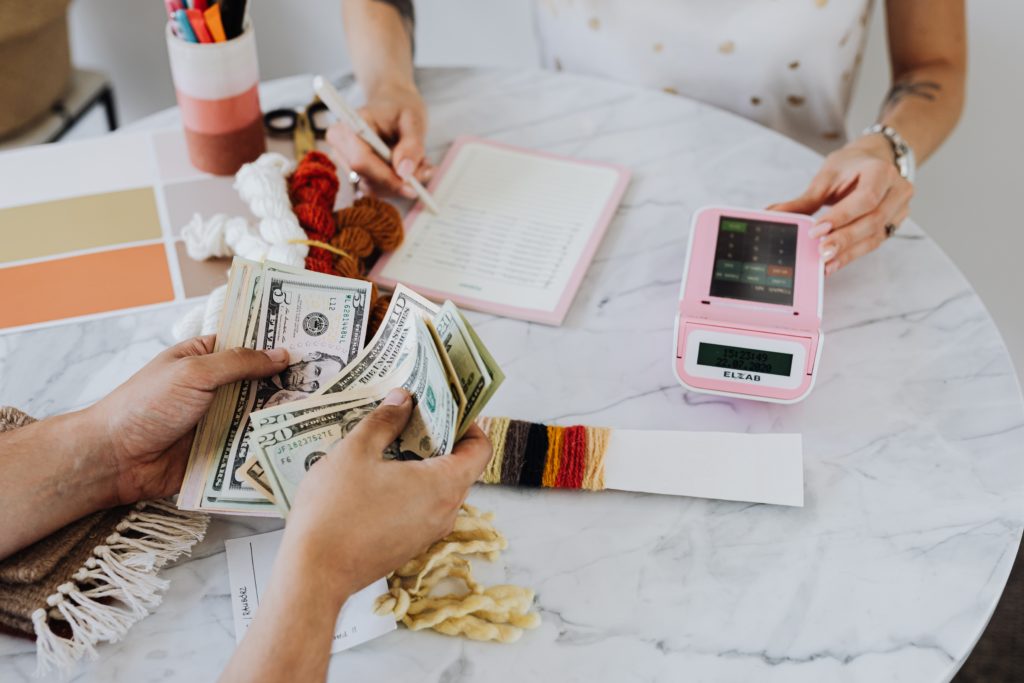 A man counting money,and a woman making a note in the diary.